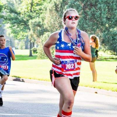 A young woman running in the FireKracker 5k.